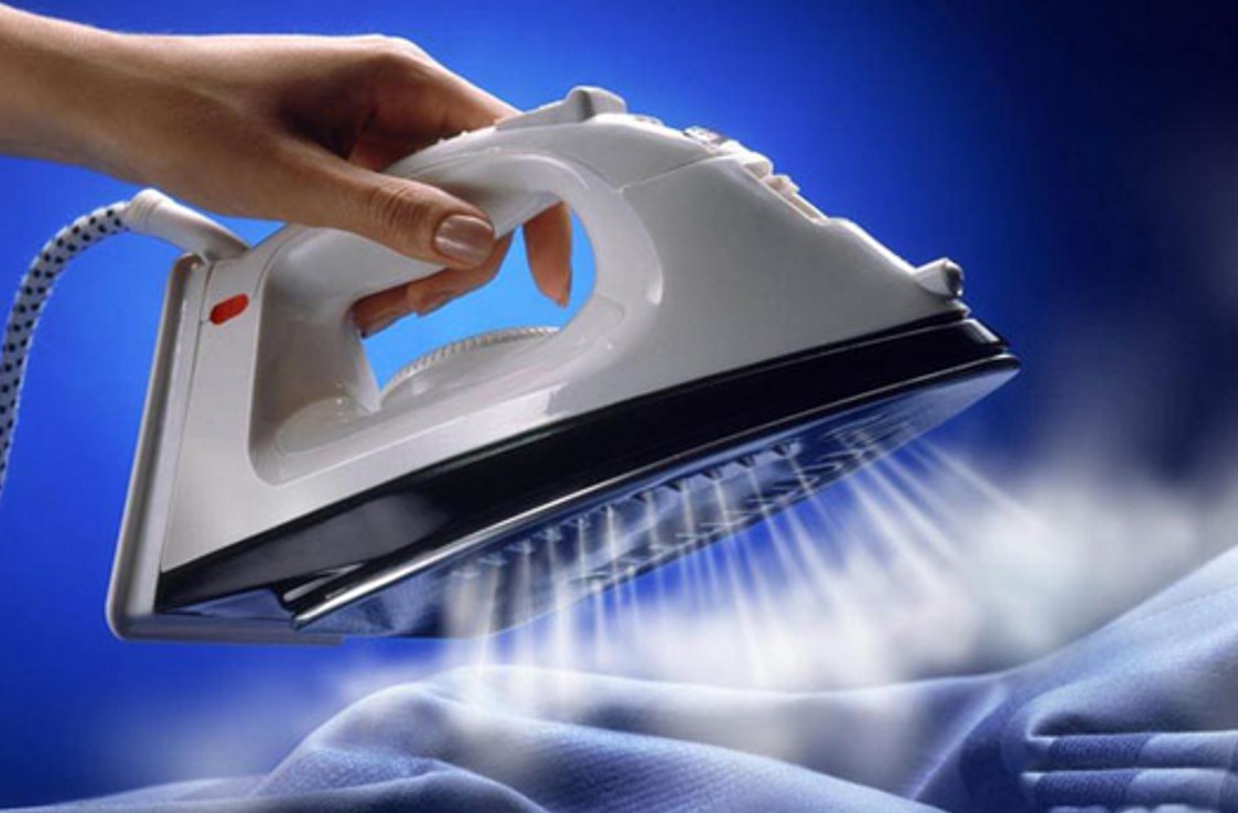 Steam iron pressing a garment